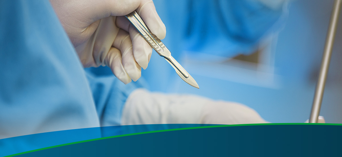 gloved hands using a scalpel